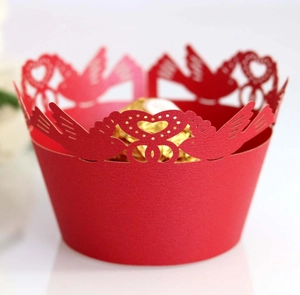 Detailed laser-cut red cupcake wrapper featuring bird and heart patterns for weddings