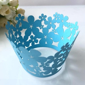 Light blue laser-cut cupcake wrappers with floral crown design for festive cake decor