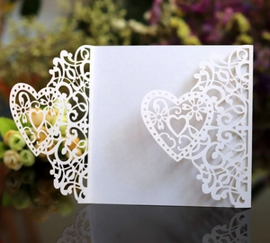 Elegant white laser cut wedding invitation card with intricate hollow heart lace patterns
