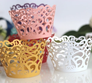 Detailed laser-cut cupcake wrappers with intricate hollow patterns in multiple colors