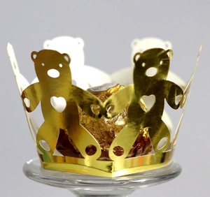 Detail of laser-cut golden bear cupcake wrapper with heart motif for chocolates