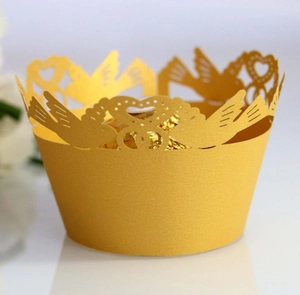 Laser-cut cupcake wrapper in shiny gold with bird and heart pattern for wedding decor