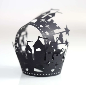 Laser-cut Halloween cupcake wrapper with black castle and star patterns on white background