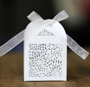 Detailed macro view of laser-cut sunflower pattern on white wedding favor gift box