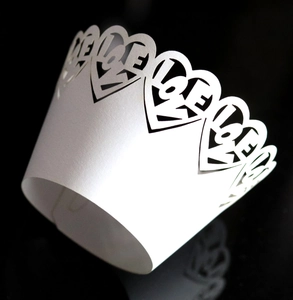 Macro detail of laser-cut heart pattern with LOVE text on pearlescent cupcake wrapper