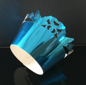 Macro detail of laser-cut heart cupcake wrappers in metallic blue for party decor