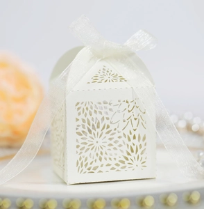 White laser-cut candy box with floral patterns and ribbon for wedding gift packaging