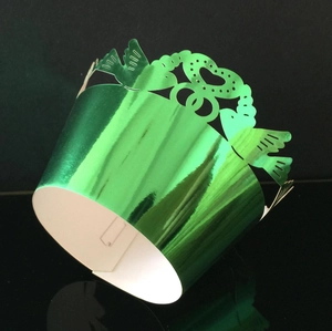 Detail of laser-cut heart pattern on green metallic mirror finish cupcake wrapper