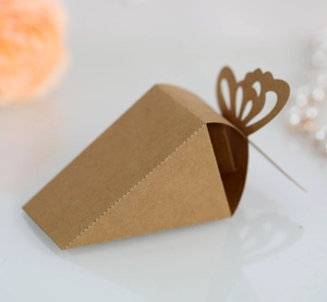 Macro detail of laser-cut butterfly closure on triangular kraft paper candy box