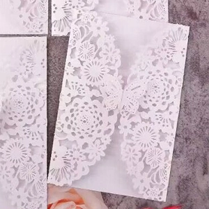 Elegant white laser-cut wedding invitation featuring intricate mandala and butterfly motifs