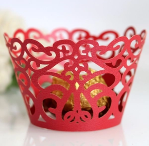 Detailed laser-cut vine patterns on red cupcake wrapper for elegant wedding table decor