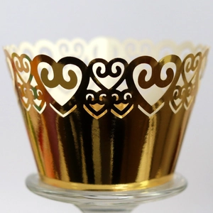 Golden laser-cut cupcake wrappers with heart patterns for wedding cake decorations