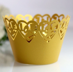 Detail of laser-cut gold pearlescent paper cake wrapper with LOVE and heart patterns