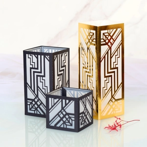 Three-piece set of geometric laser-cut candle holders in gold and black finishes