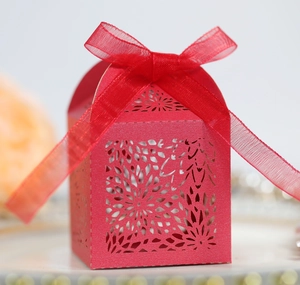 Elegant red laser-cut candy gift box with floral patterns and a satin ribbon bow