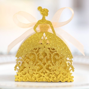 Detail of laser-cut wedding favor box in glittery gold girl silhouette with a sheer ribbon
