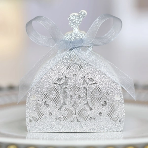 Close-up of laser-cut glitter gift box with elegant silver ribbon for wedding favors