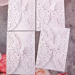 Laser cut white wedding invitation cards with hollow floral patterns and butterfly motif