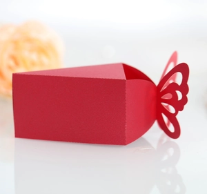 Close-up of laser-cut red butterfly candy box with sharp geometric folds for wedding