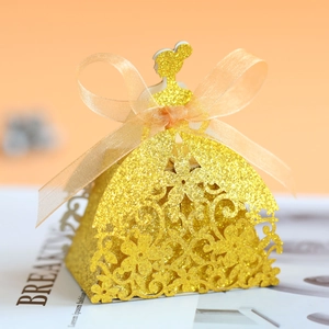 Macro shot of laser-cut princess candy box with golden glitter finish and ribbon