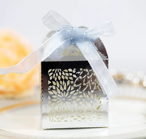 Close-up of laser-cut hollow floral candy box with light blue satin ribbon bow