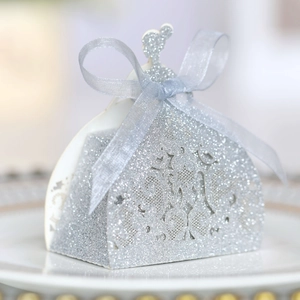 Detailed view of silver glitter hollow dress-shaped wedding favors box with ribbon