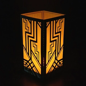 Art Deco hollow laser-cut lantern shade with warm amber light and geometric patterns