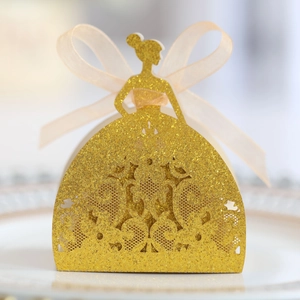 Detail of gold glitter paper favor box in gown shape with laser-cut lace and organza ribbon