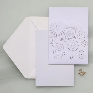 Macro view of laser-cut floral invitation set with envelope and blank inner paper