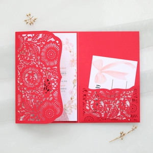 Detail of red laser-cut Chinese wedding invitation with floral Fu character pattern