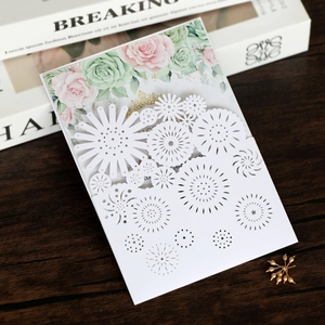 Detail of laser-cut geometric patterns and floral print on white wedding invitation card