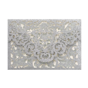 Detail of silver laser-cut wedding invitation card with glittery floral vine patterns