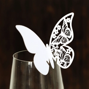 White laser-cut butterfly place card with floral patterns for wine glass decoration