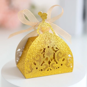 Detail of glittery gold hollow-out gown-shaped candy box with a delicate champagne bow