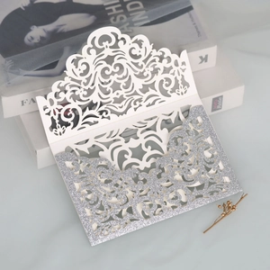 Close-up of laser-cut lace pattern on silver glitter wedding invitation sleeve