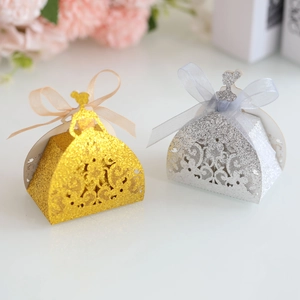 Detailed laser-cut princess dress candy boxes in gold and silver glitter paper with ribbons