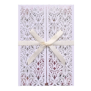 Détail de l'invitation de mariage découpée au laser avec nœud élégant et motif floral