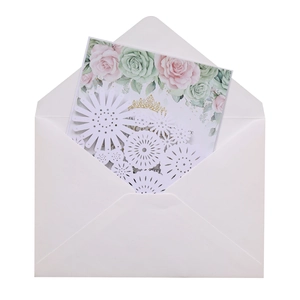 Detail of laser-cut wedding invitation with delicate white floral paper art and rose motifs