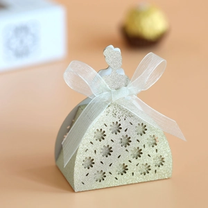Detailed laser-cut flower patterns and white organza bow on golden glitter gift box