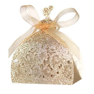 Macro detail of glitter gold hollow-out gown-shaped wedding favor gift box with ribbon