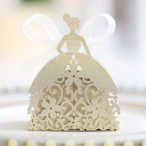 Macro view of laser-cut wedding favor box with champagne gold glitter and floral hollow design