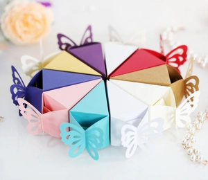Overhead view of colorful laser-cut butterfly candy boxes arranged in a cake shape