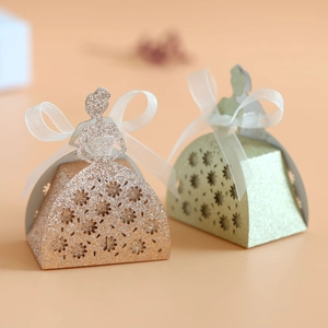 Elegant laser cut dress shaped candy boxes in rose gold and mint green with ribbons