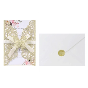 Glitter gold laser cut wedding invitation with cream ribbon bow and white envelope