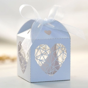 Détail de boîte à bonbons ivoire découpée au laser avec ruban en organza blanc