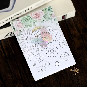 Detail of laser-cut hollow floral pattern and 3D iridescent butterfly on wedding card