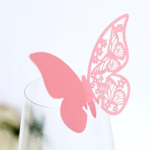 Pink laser-cut butterfly place card for wine glass rim in elegant banquet settings