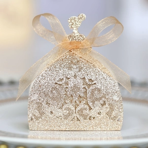 Detail of glitter gold dress-shaped candy box with hollow lace and organza bow decoration