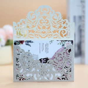 Detail of laser-cut wedding invitation with silver glitter pocket and floral insert