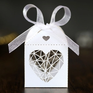 Détail de la boîte à bonbons blanche avec découpe en cœur et nœud en ruban d'organza
